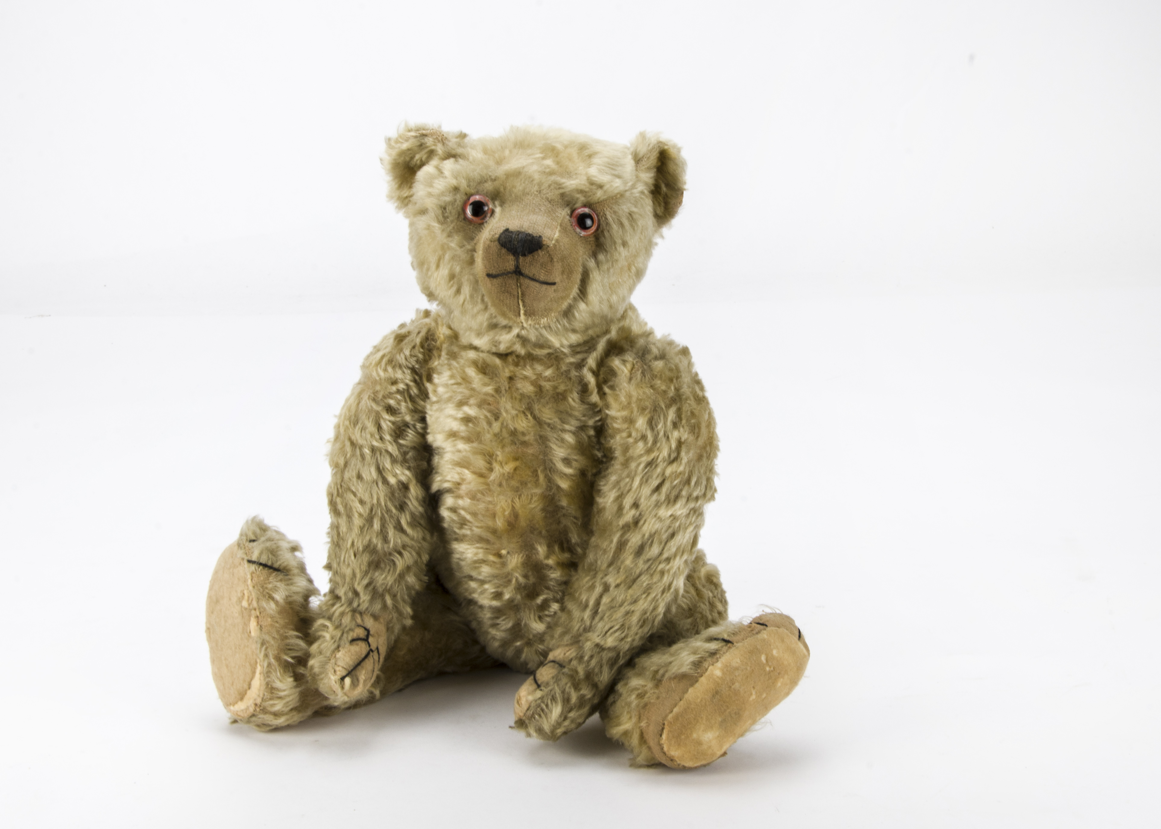 A 1920s Farnell teddy bear, with blonde mohair, clear and black glass ...