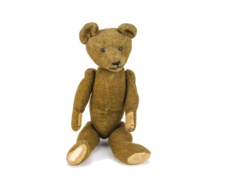 An early British burlap teddy bear 1910s, with black tin eyes, pronounced muzzle, black stitched nose and mouth, slotted-in e