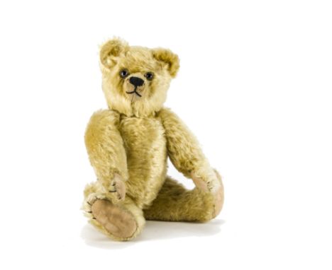 A small Farnell teddy bear 1920s, with light golden mohair, clear and black glass eyes, pronounced muzzle, restitched black n