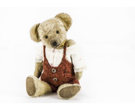 An early British teddy bear circa 1920, with light golden mohair, black boot button eyes, pronounced clipped muzzle, black st