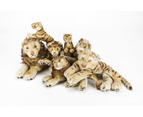 Seven post-war Steiff lions and tigers: four reclining lions, reclining tiger and two running tigers, three with buttons (som