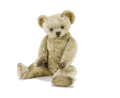 A rare early Terrys teddy bear circa 1920, with blonde mohair, clear and black glass eyes with remains of brown painted backs