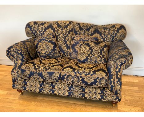 A Kirkdale three piece suite comprising of a two seater sofa, a matching armchair and pouffe, upholstered in a floral navy bl