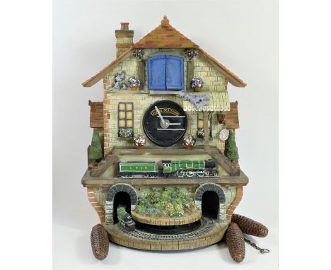 A limited edition Flying Scotsman electric cuckoo clock, made from ceramic and painted resin, depicting a railway station sce