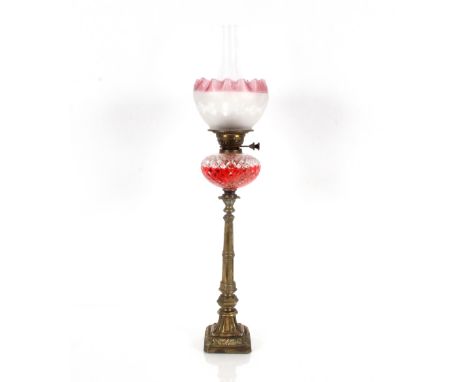 A 19th Century brass column table oil lamp, having hobnail cut reservoir and tinted frilled shade, 79cm high&nbsp;