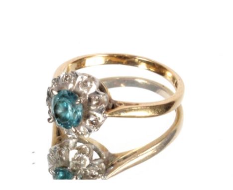 A 18ct gold ring, the central light blue round cut stone flanked by diamond chips, Size L/M, 3.4gms total weight&nbsp;