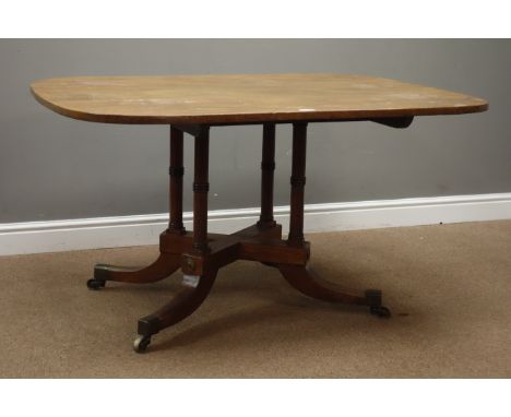 Regency style mahogany Breakfast table, rectangular tilt top on four ring turned columns and sabre legs with brass castors, W