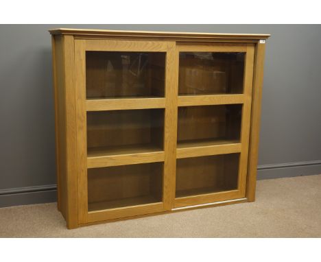 John Lewis light oak cabinet fitted with two sliding glazed doors, W134cm, H113cm, D37cm Condition Report Click here for furt