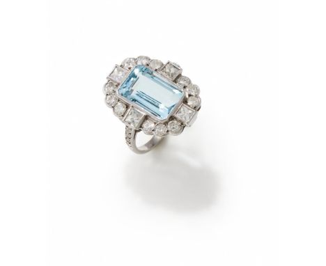 AN AQUAMARINE AND DIAMOND DRESS RING The rectangular step cut aquamarine with canted corners, within an old European cut diam