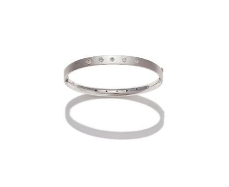 NICK KELLETT, A DIAMOND SET BANGLE The hinged 18ct white gold bangle of textured finish, inset on each side with a graduated 
