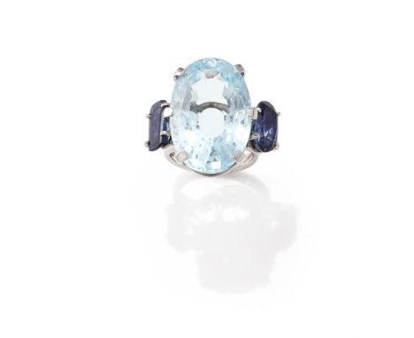 AN AQUAMARINE AND SAPPHIRE THREE STONE RING The oval cut aquamarine between an oval cut and a cushion shaped sapphire shoulde