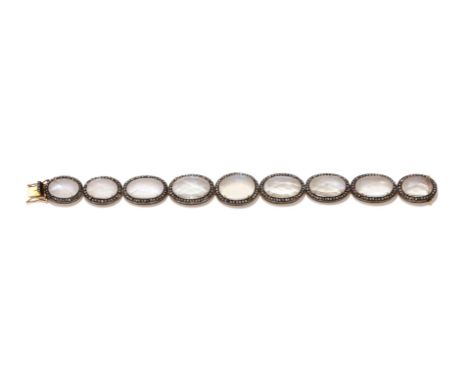 A MOONSTONE AND DIAMOND BRACELET Composed of a graduated row of facetted oval cabochon moonstones in rose cut diamond surroun