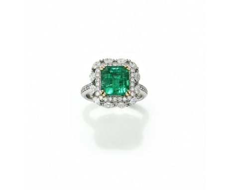 AN EMERALD AND DIAMOND CLUSTER RING The rectangular step cut emerald with canted corners, within a brilliant and marquise cut