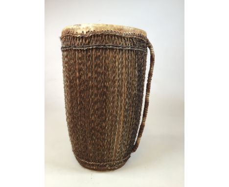 A large African double sided tribal drum with hide and string decoration and handle.W:34cm x D:34cm x H:56cm