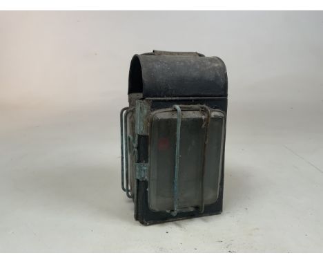 A vintage railway lantern with hinged door and metal carrying handle 