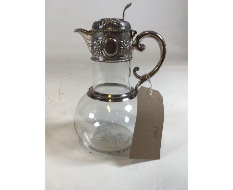 A Victorian sterling silver topped claret jug with scrolling floral decoration and vacant cartouche with star cut base by W &