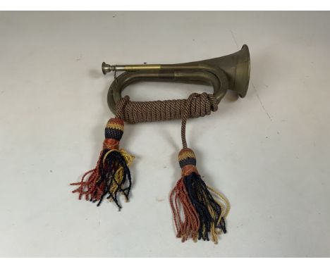A vintage brass bugle with bugle cord and tassels. No visible makers markLength: 28cm