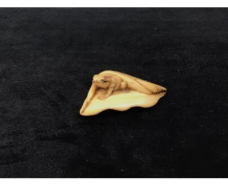 A&nbsp; netsuke of a frog emerging from leaf with two cord holes to rear W:5cm x D:3cm