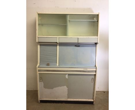 A Hygena 1950s kitchen cupboard with original patterned glass sliding cupboard to top three drawers beneath with tambour cupb