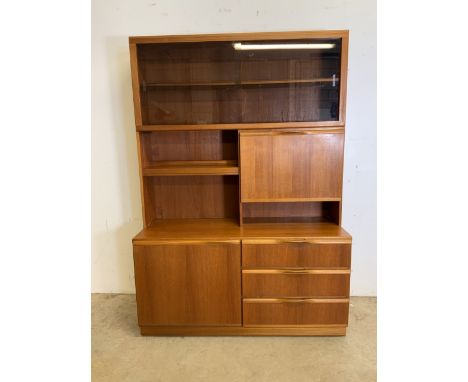 A McIntosh teak mid century two piece glazed wall unit, with smoked glass sliding doors to shelf above drop down bar, sideboa