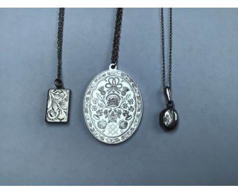A collection of sterling silver items, a royal commemorative pendant, a book locket and a small oval locket on a silver chain