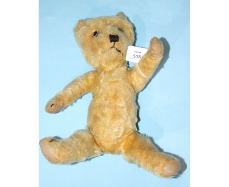 A blonde mohair plush teddy bear, possibly a Chiltern "Hugmee" with vertically stitched nose, glass eyes, cloth pads with cla