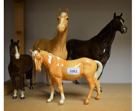 A large Beswick model of a Palomino horse, 30cm, printed mark; a similar in gloss brown, 30cm; two smaller similar (4)