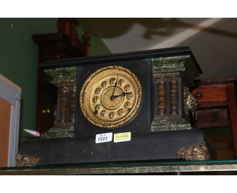 A wooden cased Mantle Clock having marble effect pillars, lion head handles, standing on metal bracket feet.  With key and pe