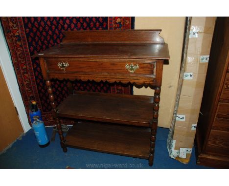 A reproduction Oak Buffet with shaped gallery back on a moulded edge top with lower fret cut detail, the two lower tiers sepa