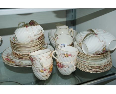 A Teaset with floral decoration, cream ground including twelve plates and cups, ten saucers, two bread and butter plates, slo
