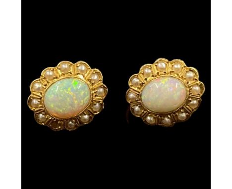 An oval opal centred around a border of split seed pearls forming a decorative pair of cluster earrings. Screw back fittings.