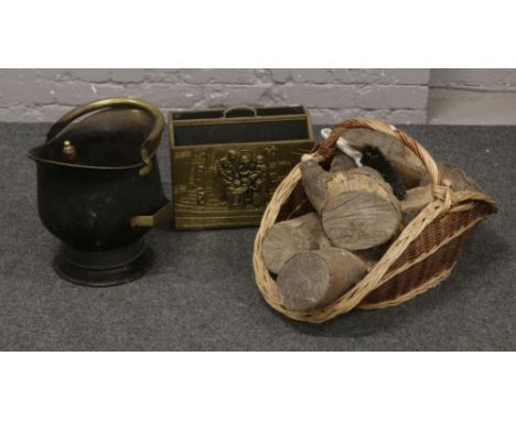 A brass helmet shaped coal scuttle along with a brass magazine rack and a fireside basketware log basket and contents of logs