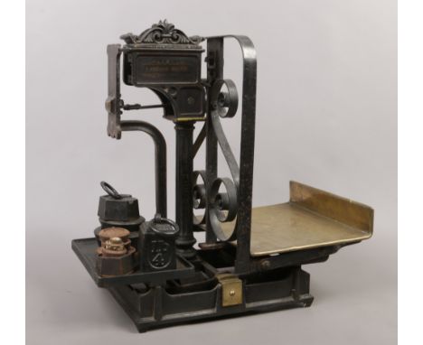 A set of late 19th / early 20th century ornate brass and cast iron shop weighing scales, with a quantity of weights.