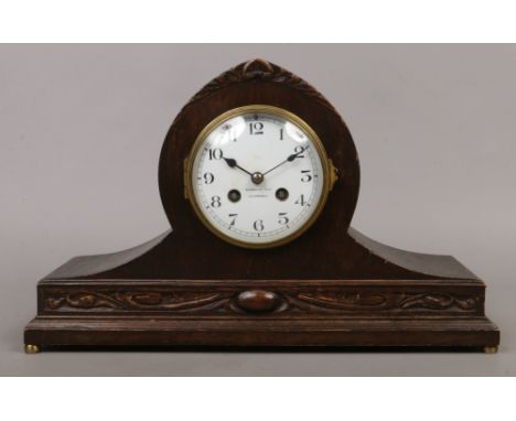 A carved oak cased mantle clock with white enamel dial marked Russels Limited Liverpool and French movement chiming on a coil