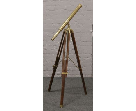 A reproduction brass telescope marked spuriously Ross, London. On brass and mahogany tripod, with focusing barrel and object 