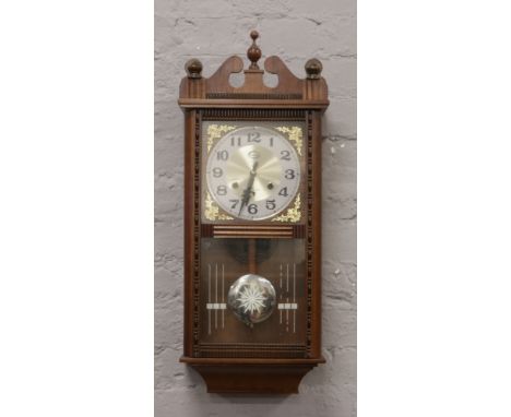 A mahogany cased 31 day wall clock chiming on a coiled gong with pendulum and key.