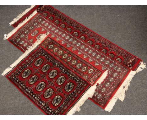 Four carpet runners, red ground with geometric designs, two 190cm x 65cm and two 100cm x 63cm.