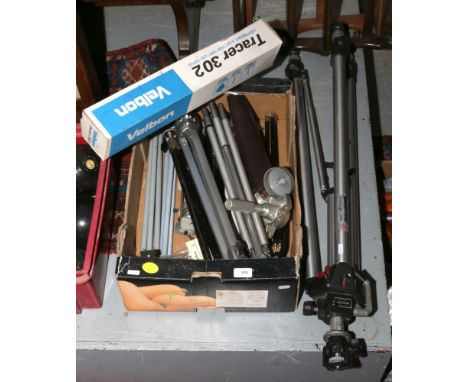 A box of various photographic tripods including Manfrotto and Velbon examples.