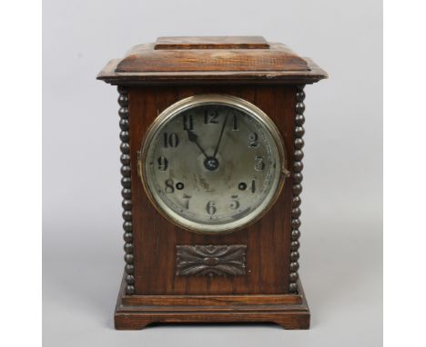 A carved oak mantle clock with silvered dial and Arabic numeral markers with pendulum and key.Condition report intended as a 