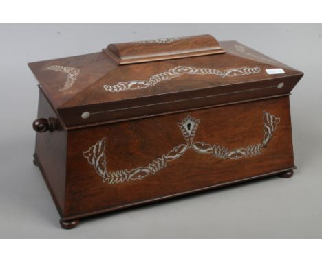 An early Victorian rosewood sarcophagus formed tea caddy with fitted interior and mother of pearl inlaid floral decoration.Co