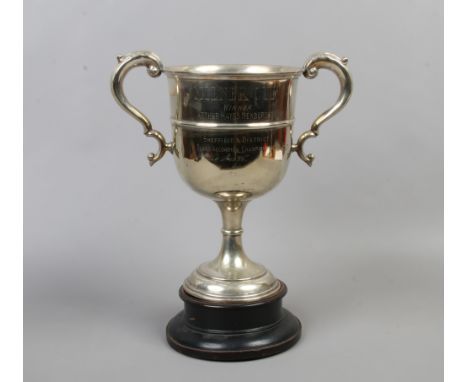 A large silver plate twin handled presentation cup raised on ebonised plinth. Milner Cup Winner, Piano Accordion Championship