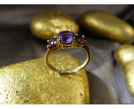 9ct Amethyst and Garnet Ring, central Amethyst approx 5.4mm diameter with an approx 3.9mm diameter Garnet either side. Size U