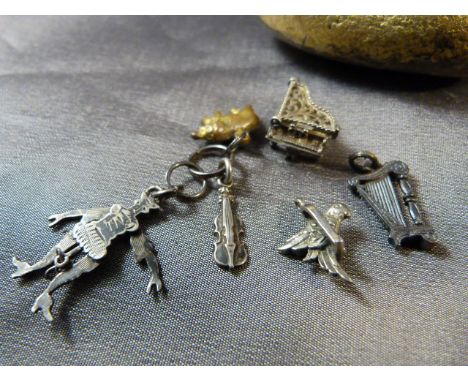 Collection of small charms - Piano with lift filigree top, Harp, bird on swing, others and an Articulated Clown pendant. Arm 