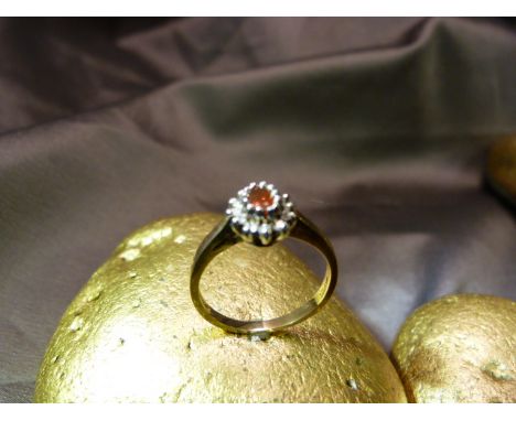 9ct Ruby and Diamond cluster ring. The oval ruby is surrounded by 12 (.10pts) of Sparkling Diamonds and measures approx 9.16m
