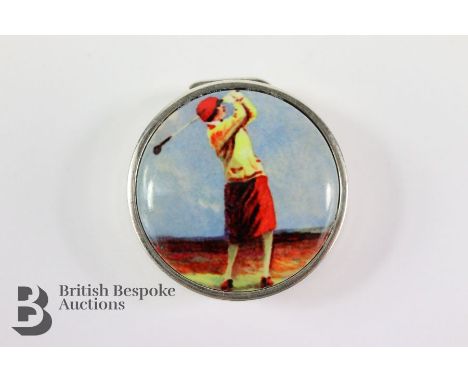 A silver pillbox with enamel pictorial plaque depicting a golfer, approx 30 mm in diameter, approx 15 gms.&nbsp;
