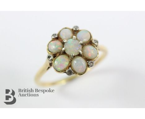 Antique 18ct (tested) opal and diamond ring. The ring set with a central opal measuring 4mm surrounded by six 4 x 3 mm opals 