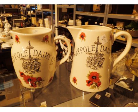 Two large ceramic jugs decorated with poppies bearing the words Maypole Dairy  CONDITION REPORT: No apparent damage. Age unce