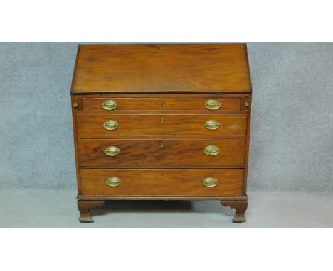 A Georgian mahogany bureau with secret compartment inside fitted interior above four long graduating drawers, raised on brack