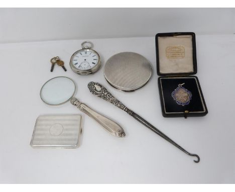 A collection of silver items including a silver pocket watch, antique silver compact, silver repousse boot hook, silver and e