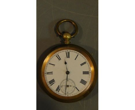An antique brass pocket watch with bevelled glass and white enamel dial with black Roman numerals, second dial. Engraved to t